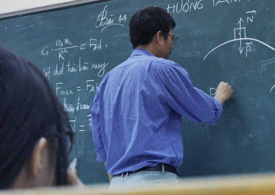 Picture of a teacher writing on a chalkboard