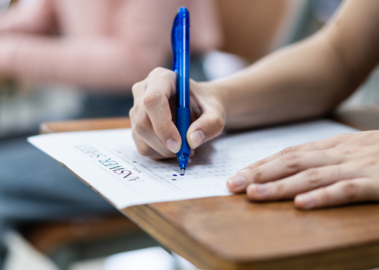 A person is sat with an exam paper